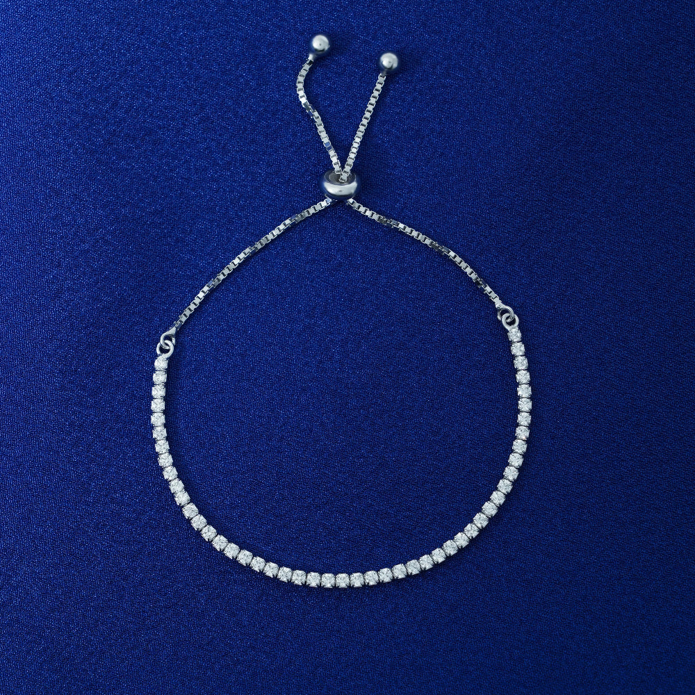 Silver tennis bracelet on a blue background