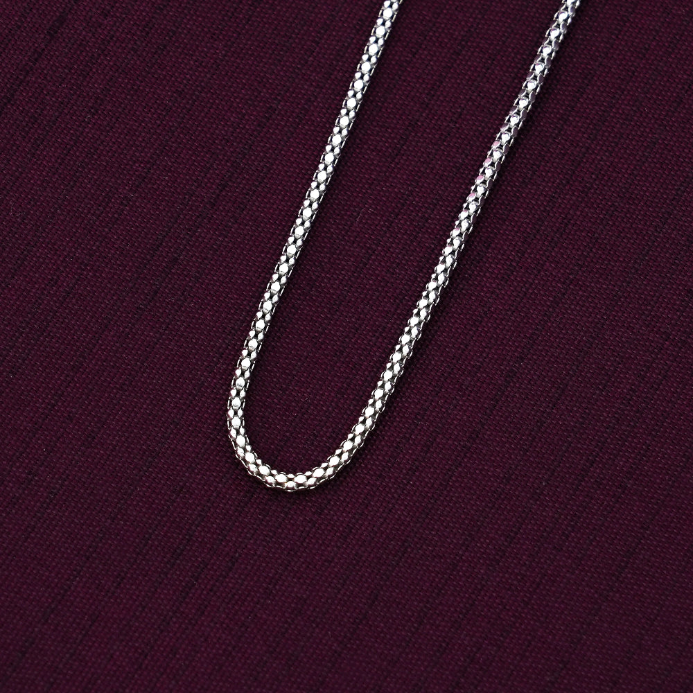 Silver crub chain on a dark purple fabric background