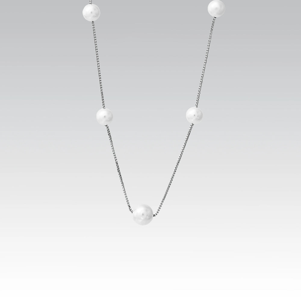 Pearl necklace with silver chain on a light gray background