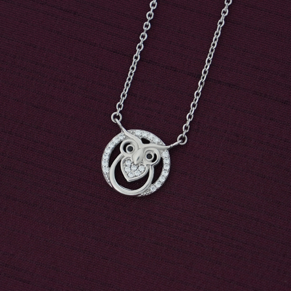 Silver necklace with a circular pendant on a dark purple background