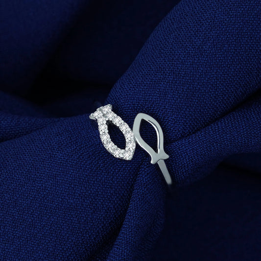 Silver ring with diamond accents on a blue fabric background