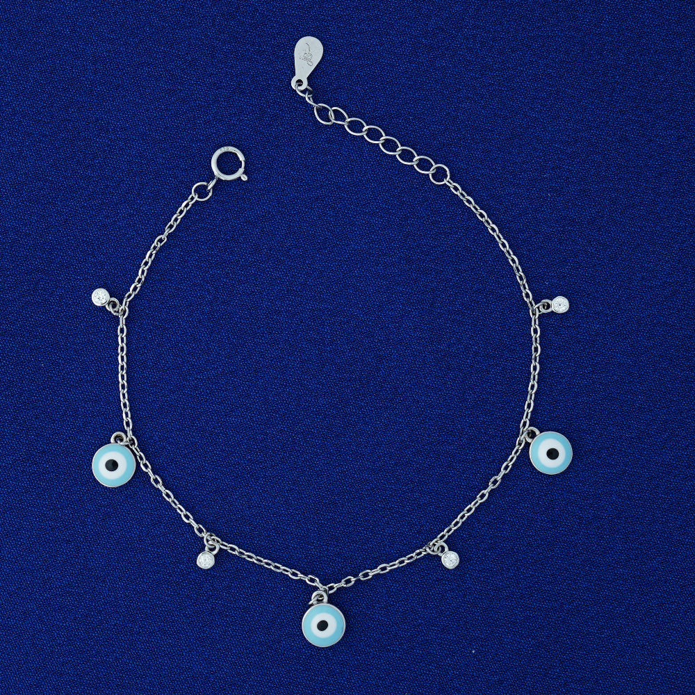 Silver bracelet with blue evil eye charms on a blue background