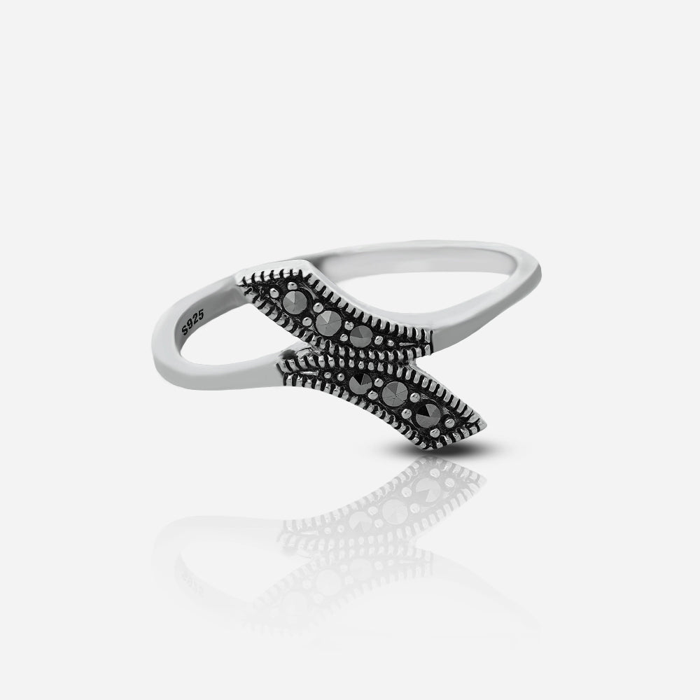 Silver ring with black gemstones on a white background