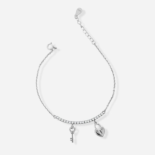 Silver bracelet with heart and key charms on a white background