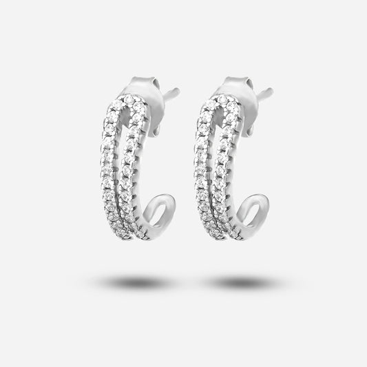 Pair of silver earrings with clear gemstones on a light gray background