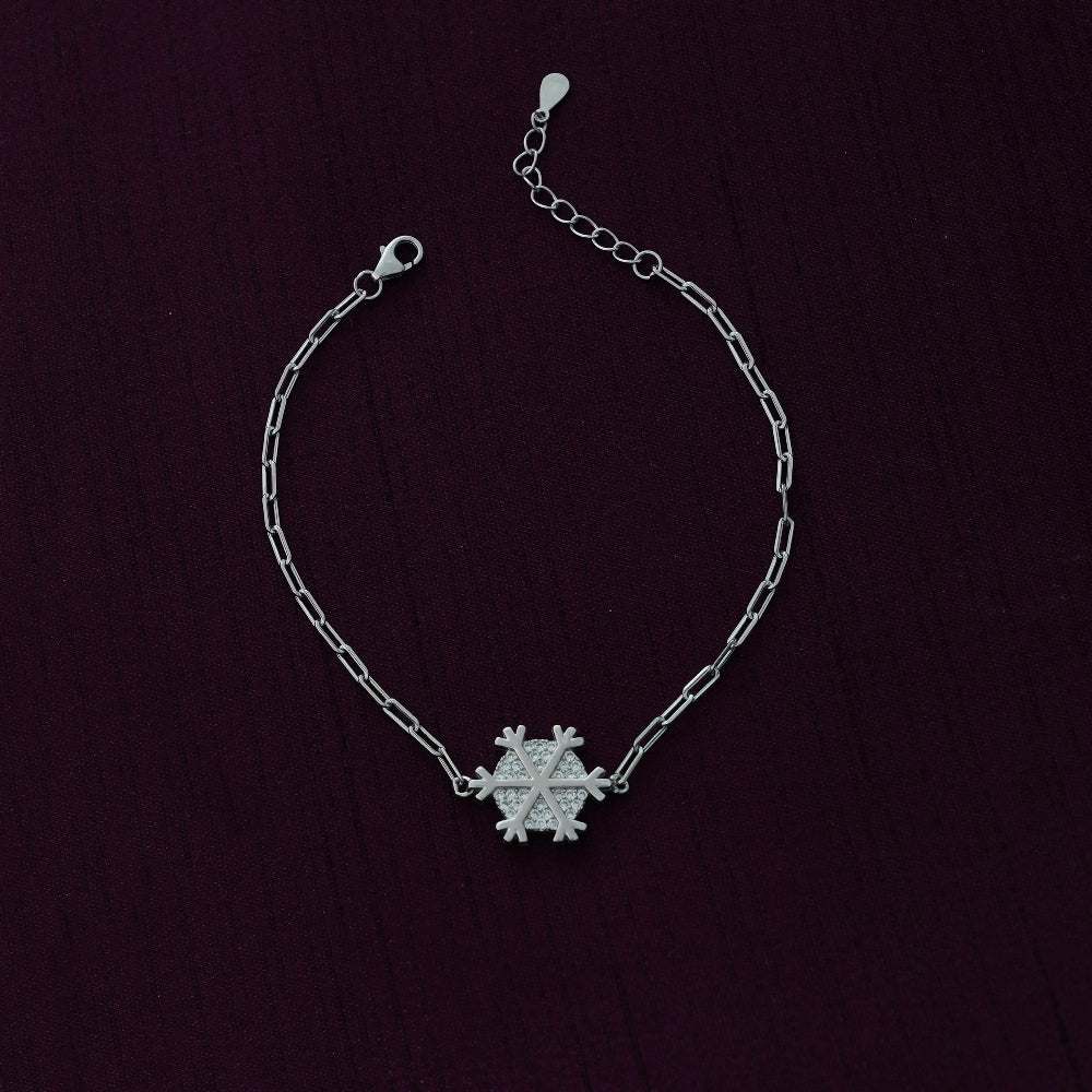 Silver chain bracelet with a snowflake charm on a dark background