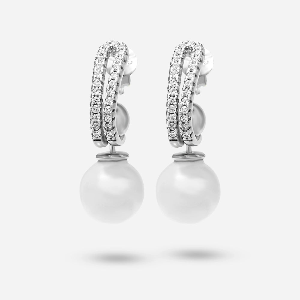 Pearl earrings with diamond accents on a light gray background
